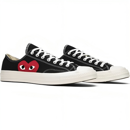 a pair of black shoes with red eyes and a heart on the side