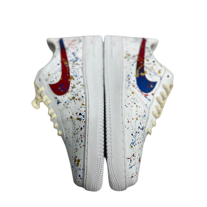 a pair of white shoes with colorful drops on it