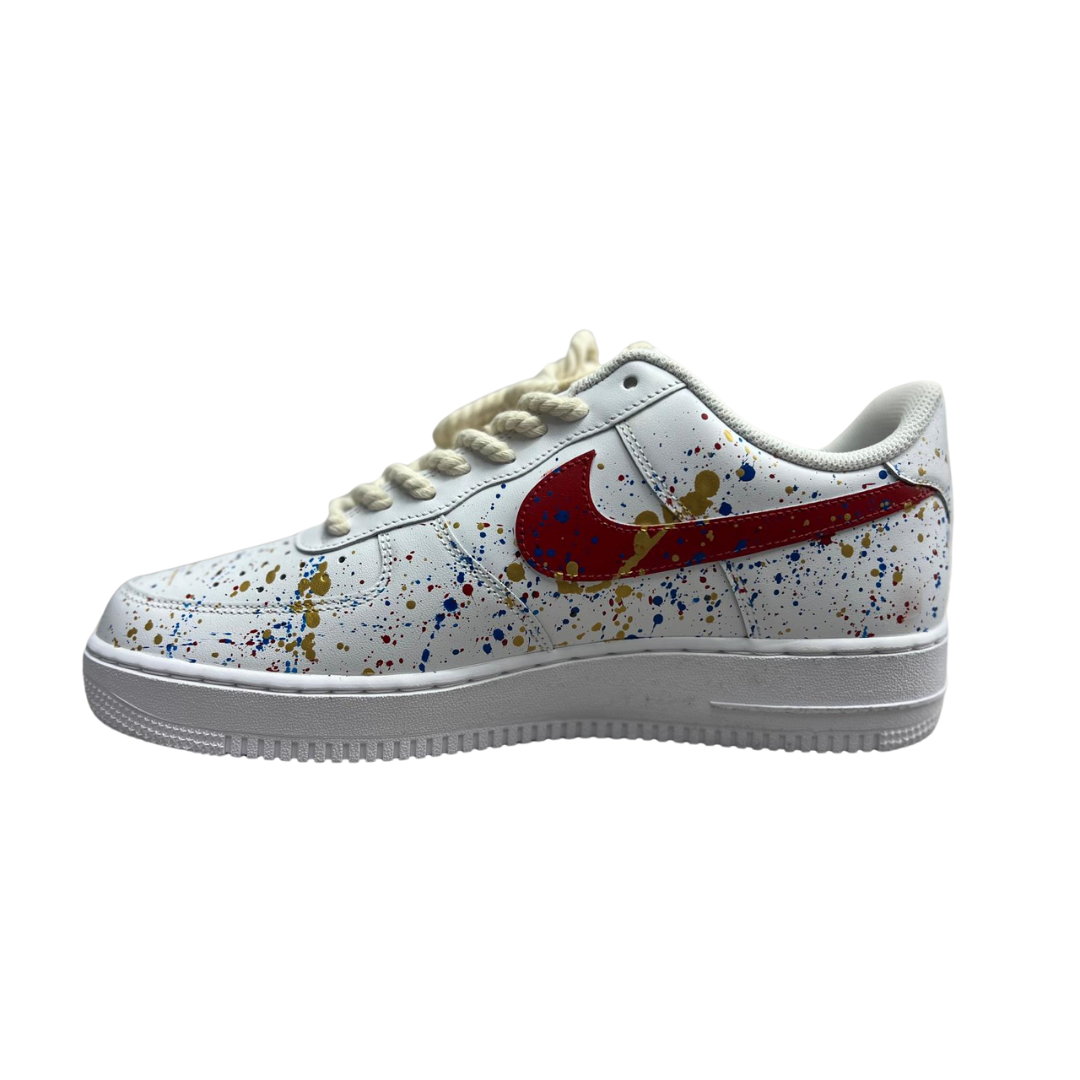 a white shoes with splatter paint on it