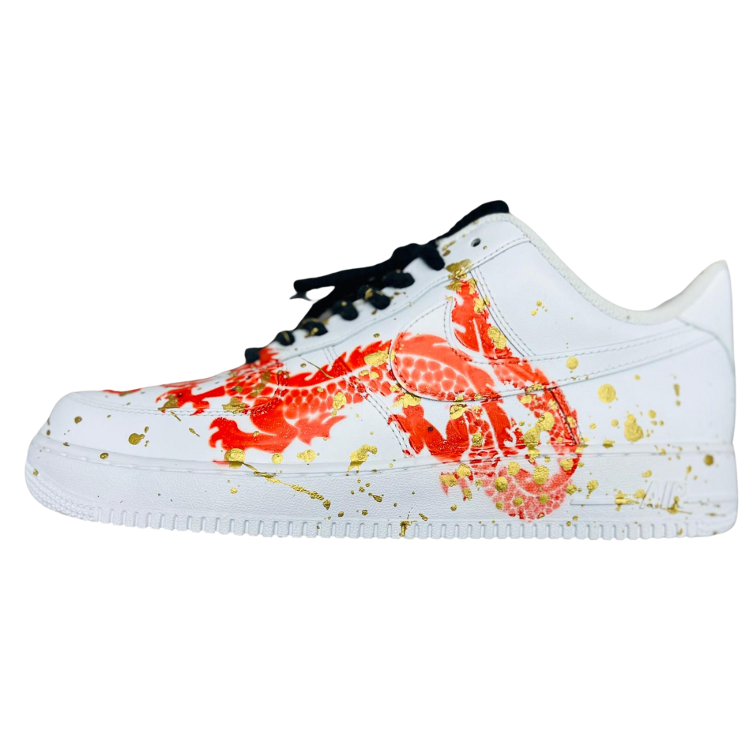 a white shoe with orange snake and golden drops on it