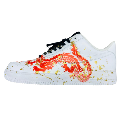 a white shoe with orange snake and golden drops on it