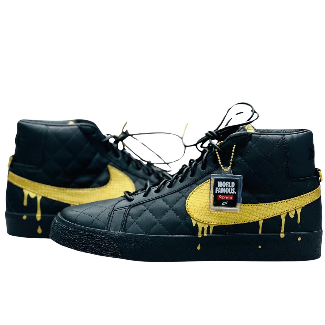 a pair of black shoes with yellow paint dripping on them