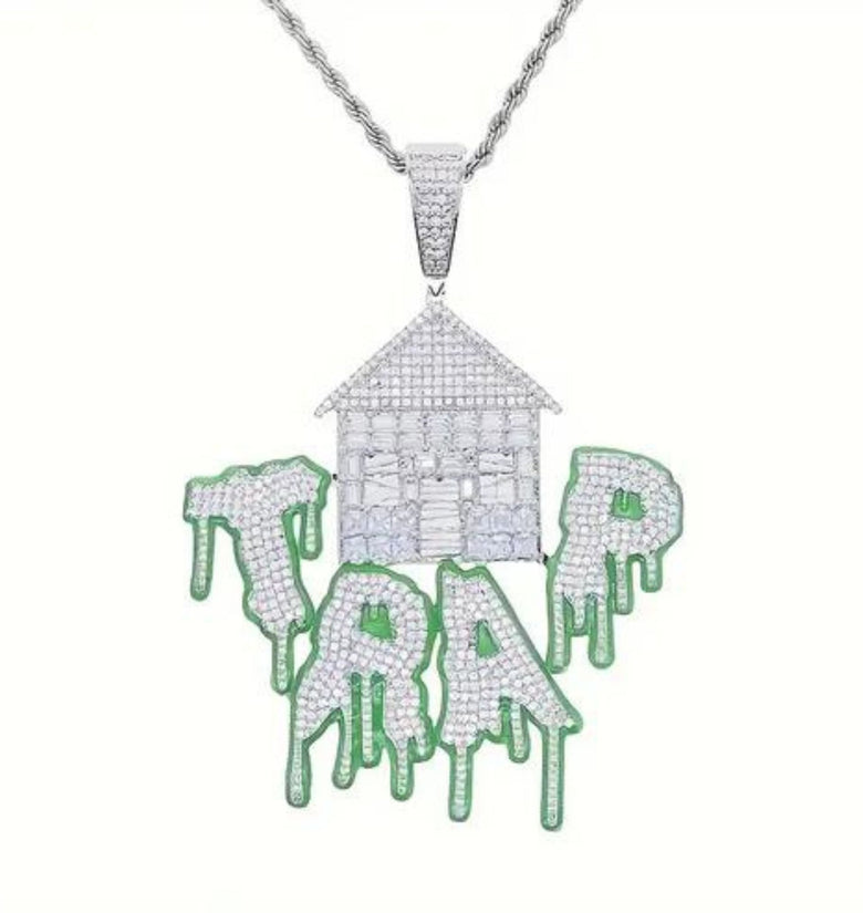a necklace with a house and dripping paint