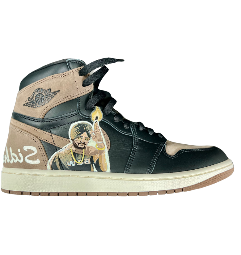 a black and brown shoe with a picture of a person holding a candle