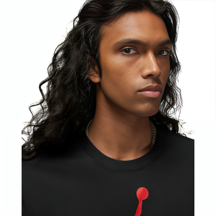 a person with long hair wearing a black shirt with a red pin on it