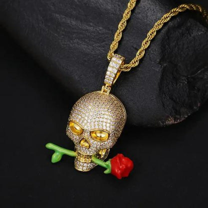 a gold necklace with a skull and a rose