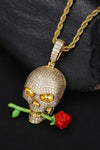 a gold necklace with a skull and a rose