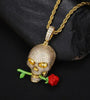 a gold necklace with a skull and a rose