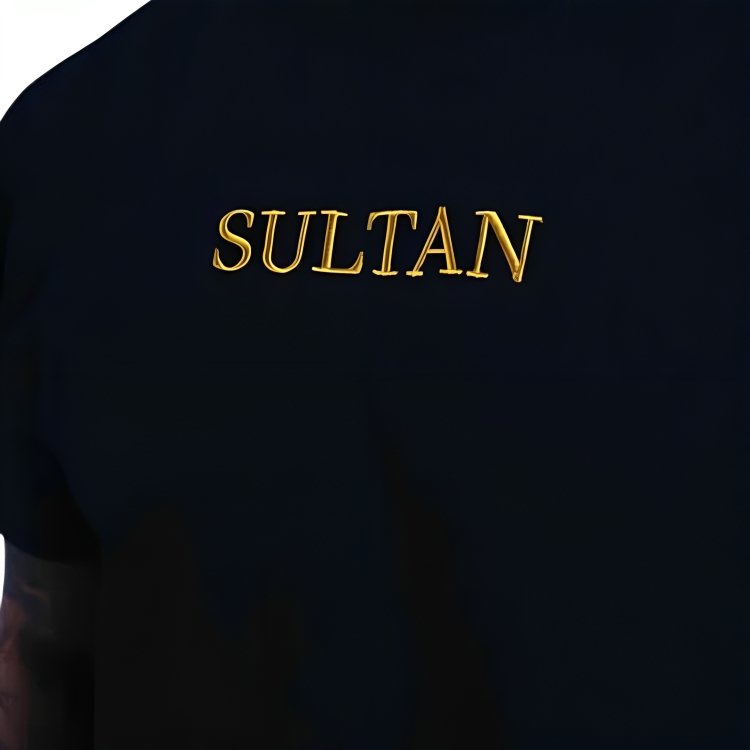 a person wearing a black shirt with a sultan print on it