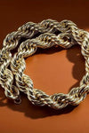 a gold chain on a brown surface