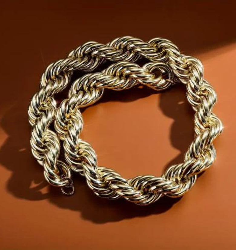 a gold chain on a brown surface