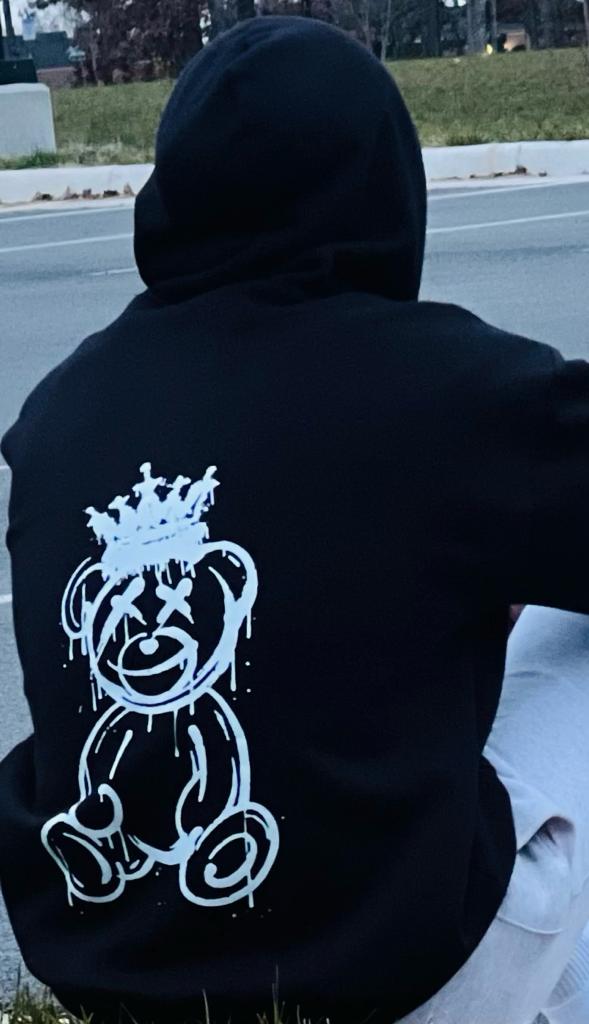 a black hoodie with a white drawing of a teddy bear